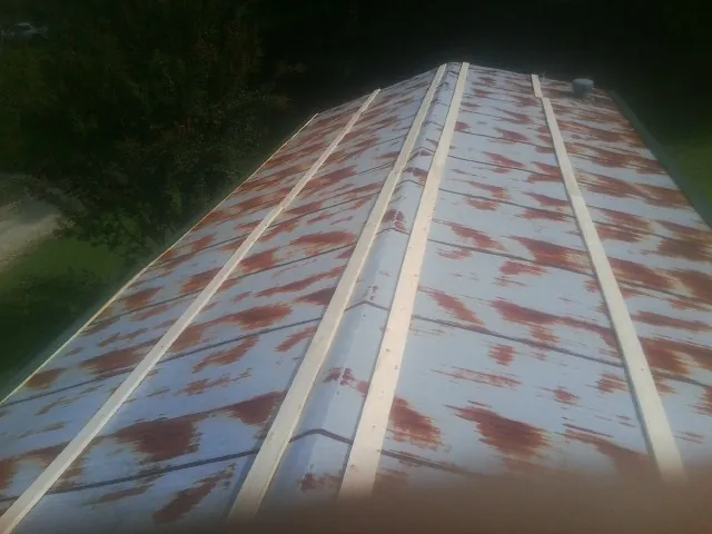 Rusted metal roof panels with new wood purlins before replacement — Storm Damage Roof Repair in Highwood by Roofing Brothers