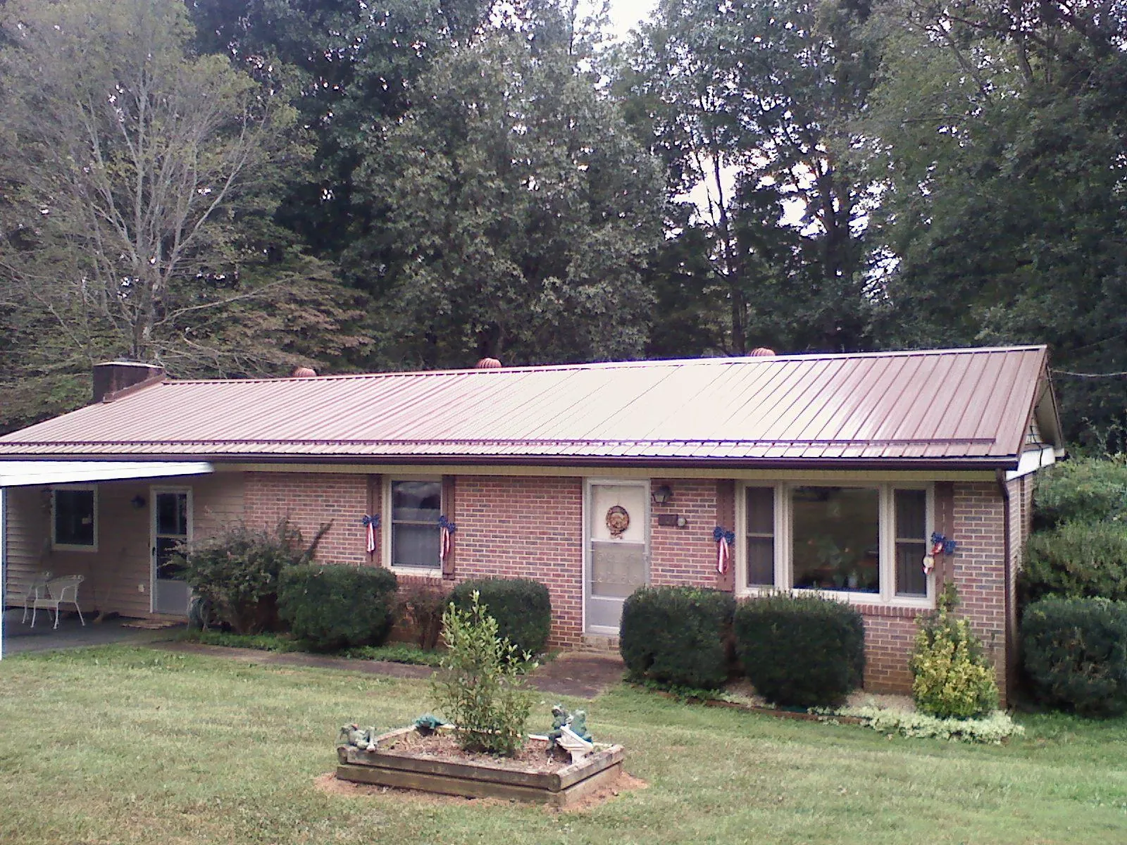 Bronze metal roof on a brick ranch home with a carport in Highwood