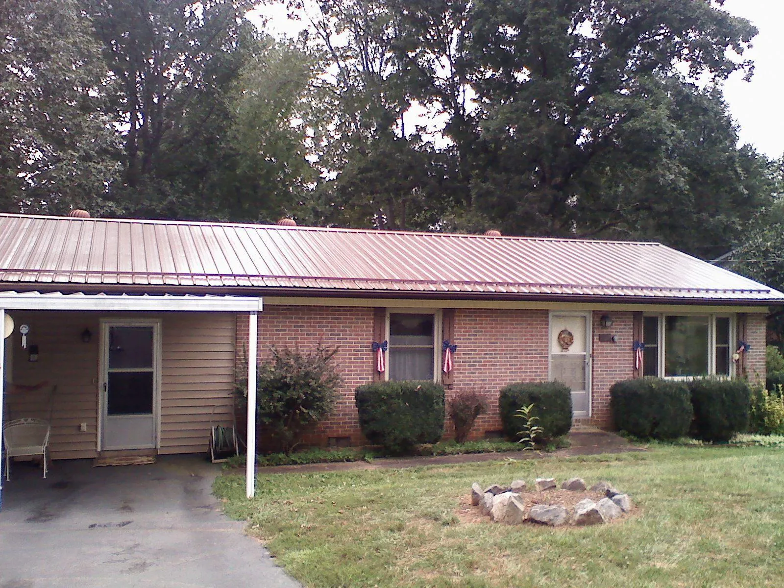 Bronze metal roof and carport on a brick ranch home — Roof Repair work by our crew in Highwood