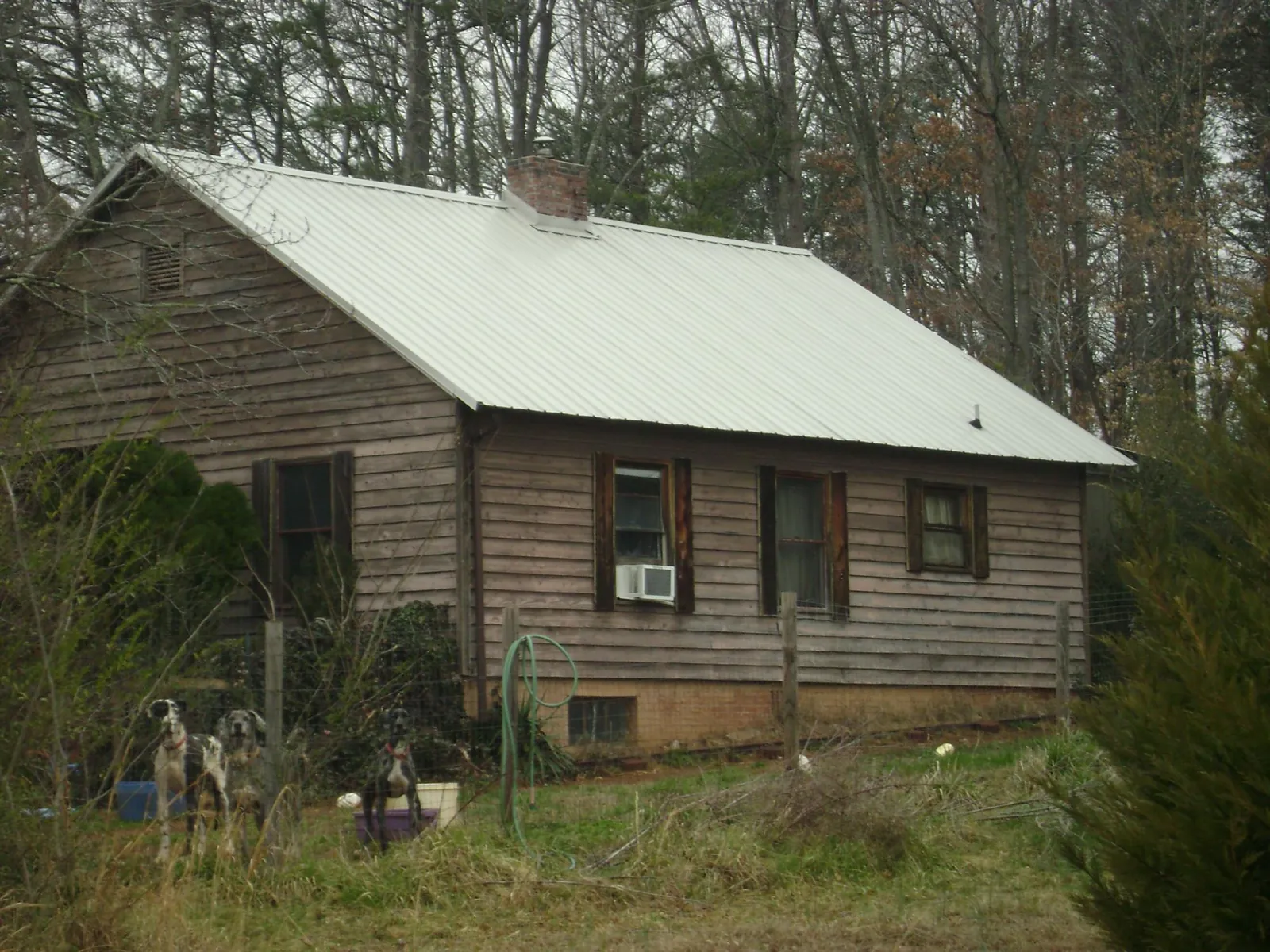 White metal roof on an old wood sided farmhouse, from a Metal Roof Installation job in Highwood